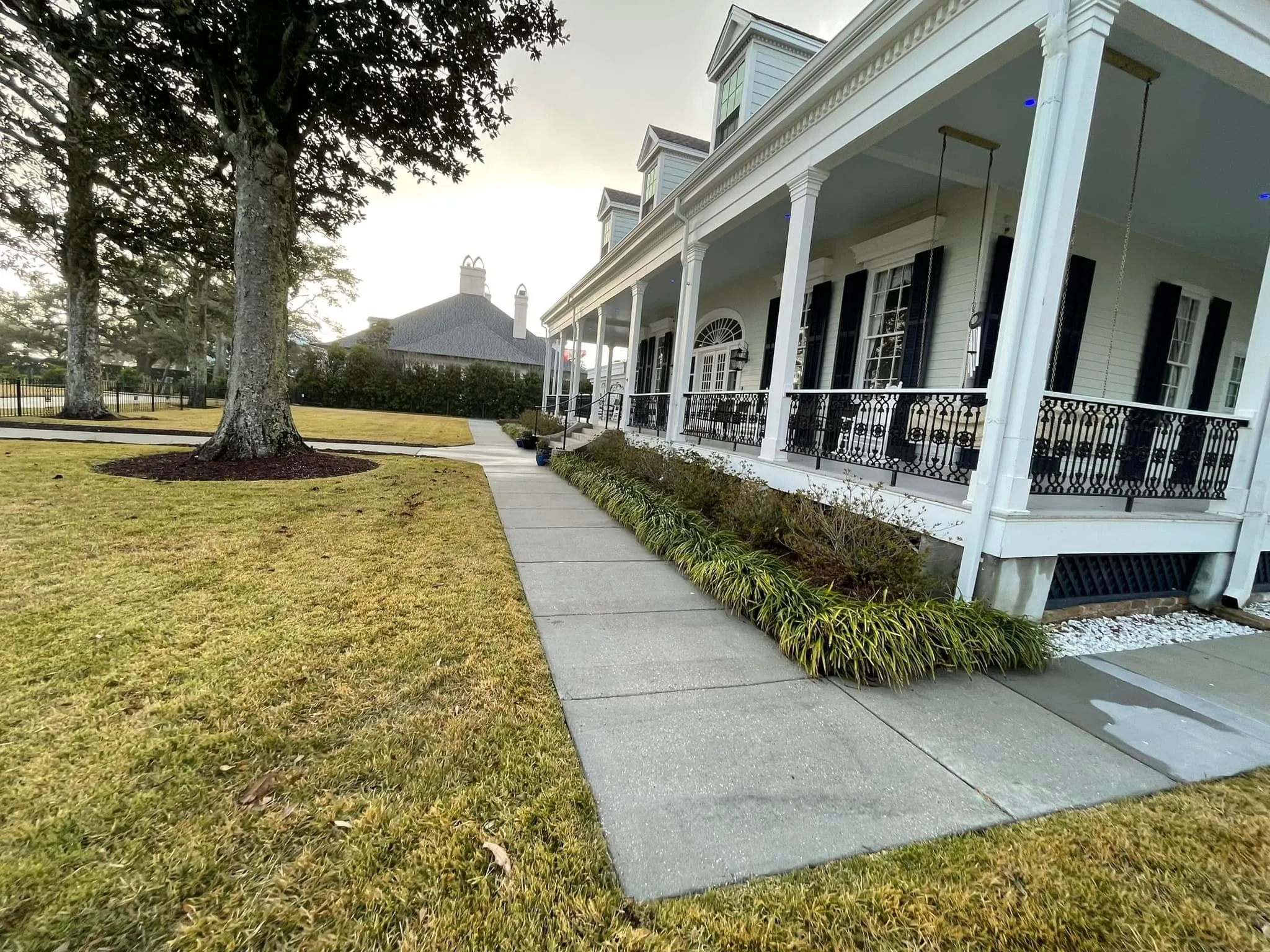 Clean concrete walkway leading to a white Gulf Coast house after a Kleen Tek wash