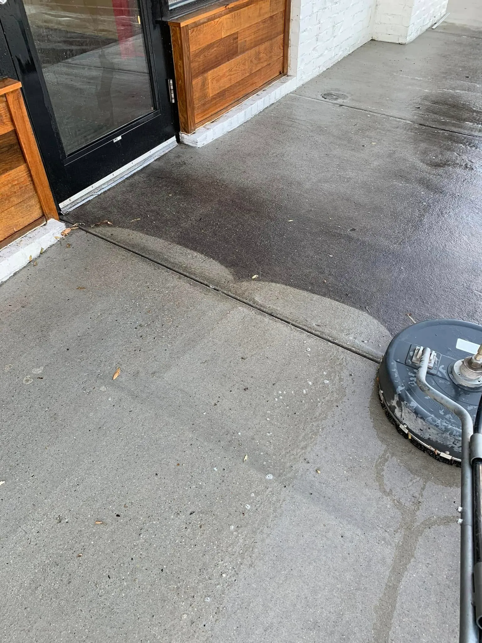 Pressure washing a commercial sidewalk with a surface cleaner.